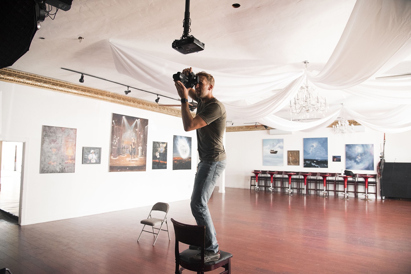 Nick Isabella taking a photo standing on top of a high chair