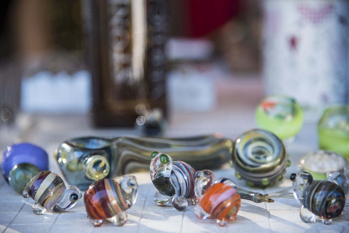 Close-up of small blown glass figurines of turtles and pipes.